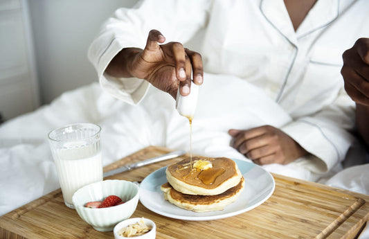 Petit-déjeuner avec des pancakes arrosés de miel, illustrant l'utilisation du miel à index glycémique bas