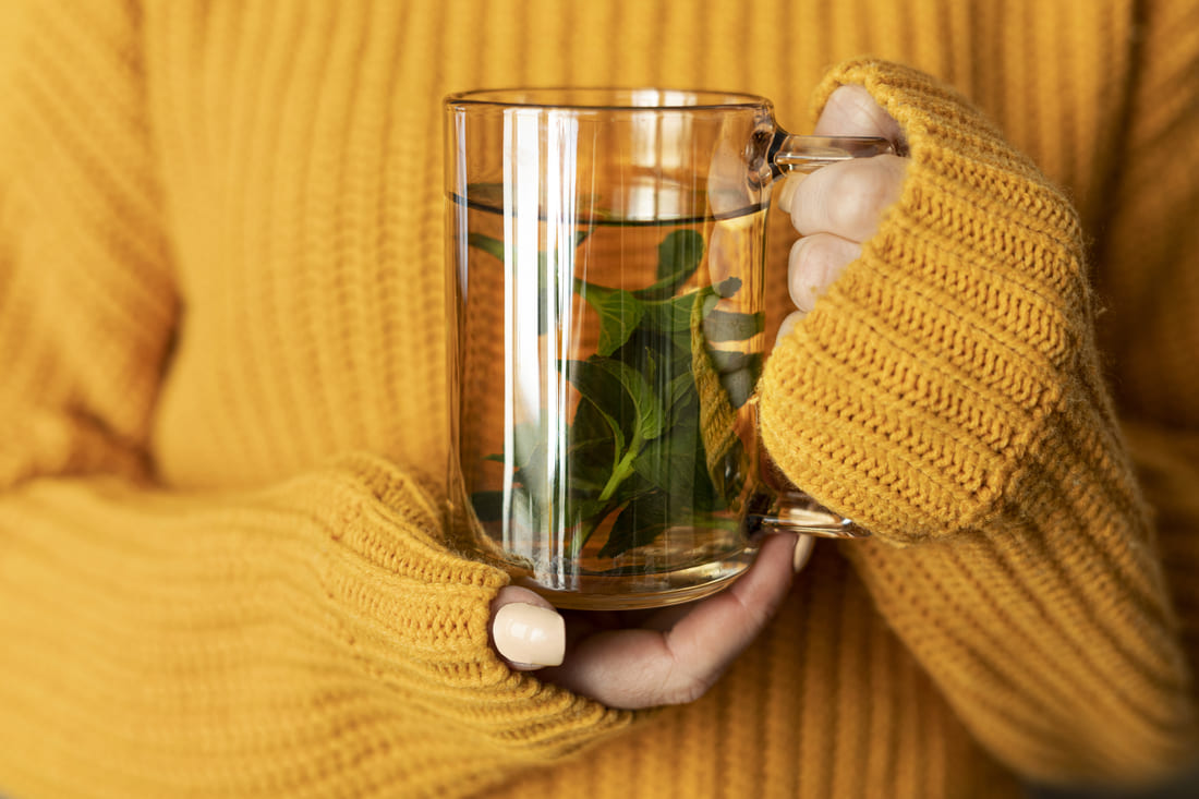 Femme tenant un mug dans ses mains qui a préparé un remède naturel pour le rhume