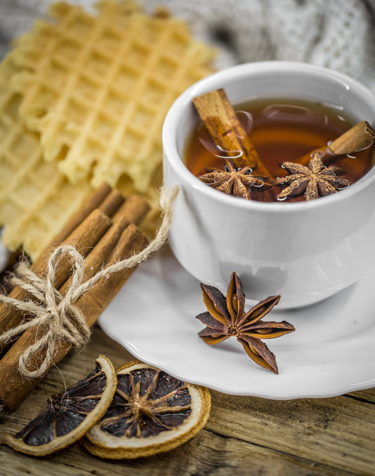 Image représentant une tasse de thé accompagnée de miel et de cannelle, utilisée pour traiter le cholestérol naturellement.